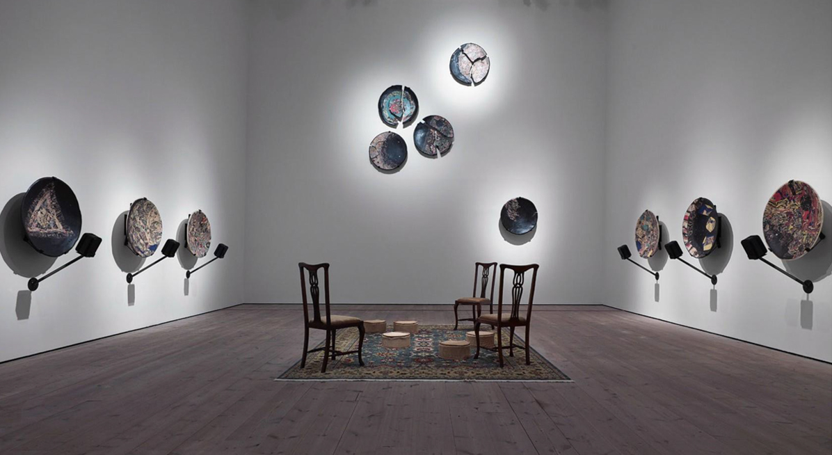 Art Gallery with wall mounted sculptures and chairs on a rug